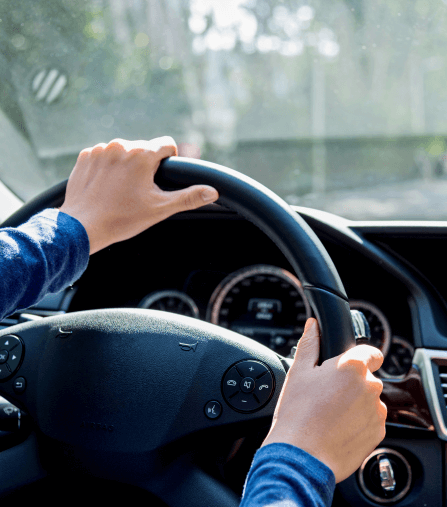 Hands gripping a steering wheel while driving